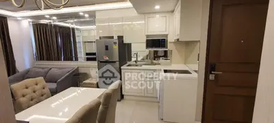 Modern open-layout kitchen and living room with sleek appliances and elegant dining area.