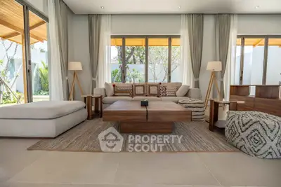 Luxurious living room with modern decor and large windows overlooking a garden.