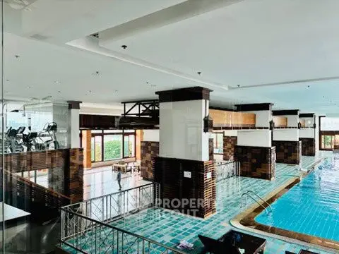 Luxurious indoor pool area with modern gym facilities and elegant design.
