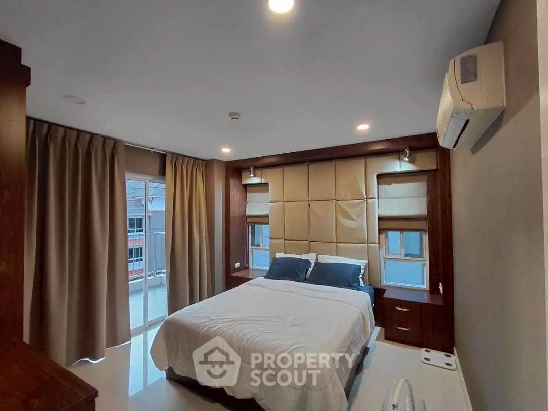 Modern bedroom with elegant design and natural light from large windows.