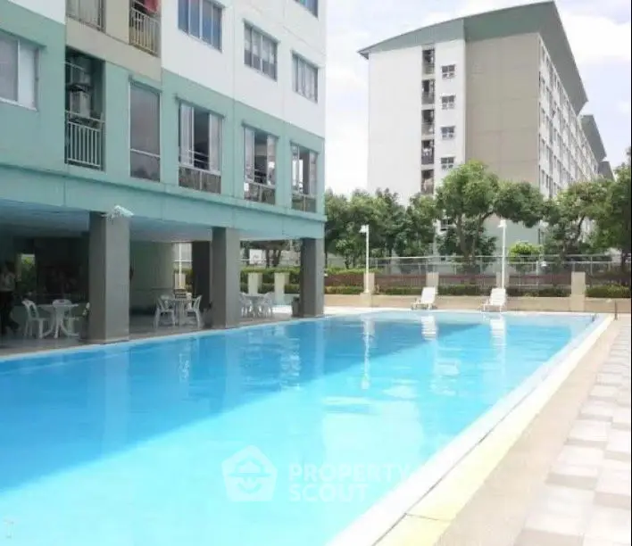 Modern apartment complex with inviting outdoor swimming pool and seating area.