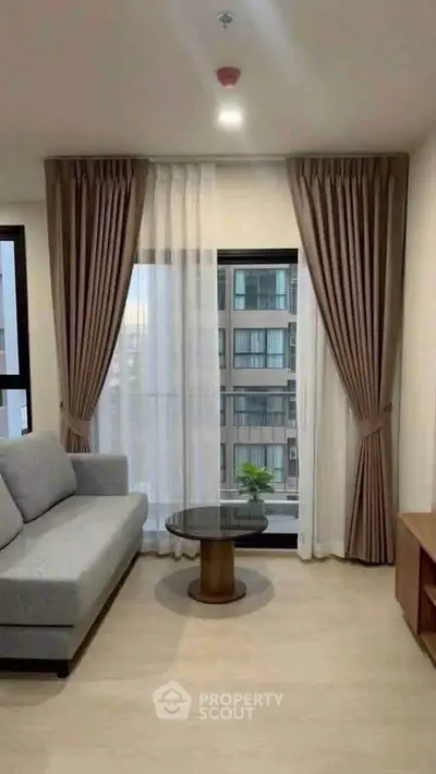 Modern living room with elegant curtains and city view, featuring a cozy sofa and stylish coffee table.