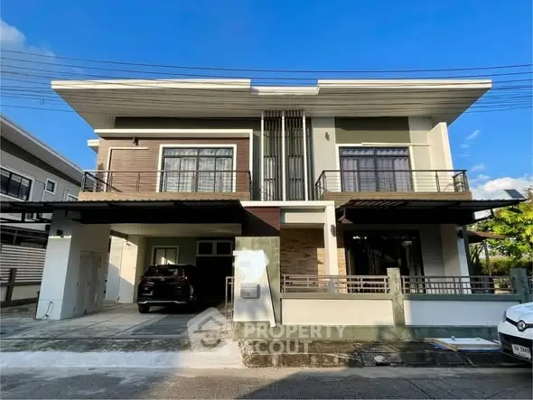 Modern duplex house with sleek design and spacious driveway in a suburban neighborhood.