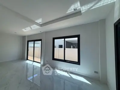 Spacious modern living room with large windows and marble flooring