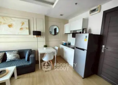 Modern compact living room with integrated kitchen, stylish decor, and cozy seating area.
