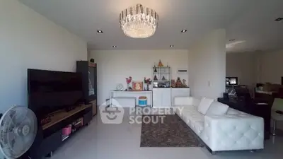 Spacious living room with elegant chandelier and modern white sofa