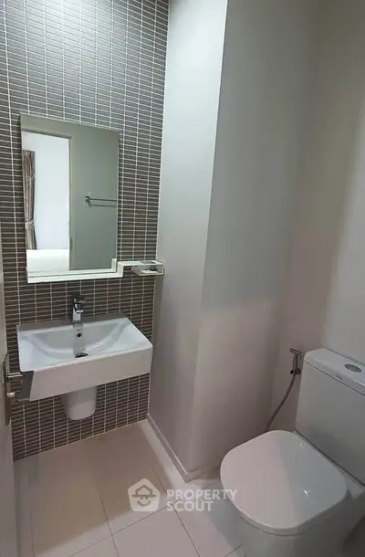 Modern bathroom with sleek sink and toilet in minimalist design.