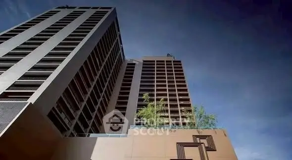 Modern high-rise building with sleek architecture and clear blue sky backdrop.