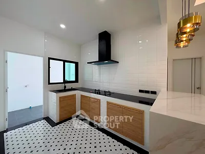 Modern kitchen with sleek design, featuring gas stove and stylish lighting, perfect for culinary enthusiasts.