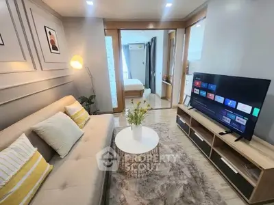 Modern living room with cozy sofa and smart TV, open layout to bedroom