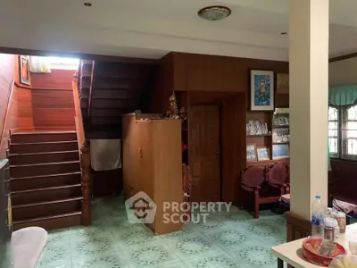 Charming interior with wooden staircase and cozy seating area, perfect for a warm family home.