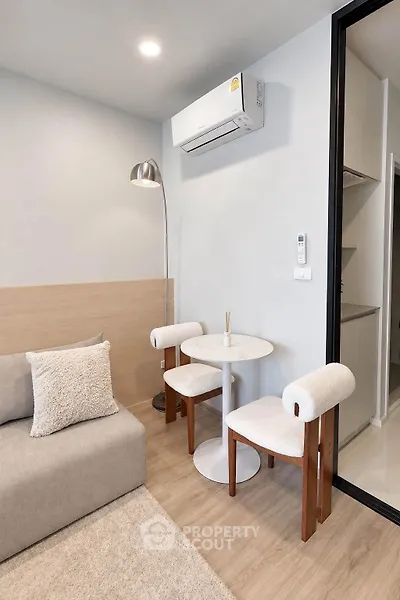 Modern living room with cozy seating and air conditioning in a stylish apartment.