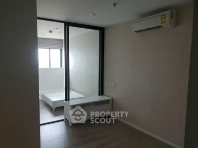 Modern bedroom with air conditioning and sliding glass door to adjoining room.