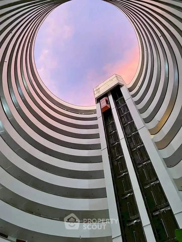 Stunning architectural view of a modern circular building with a central elevator shaft.