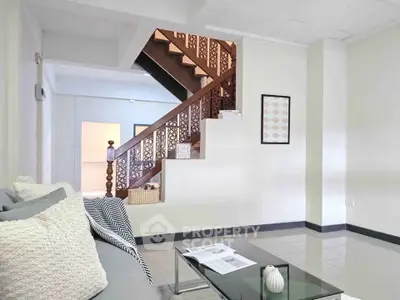 Spacious living room with elegant staircase and modern decor