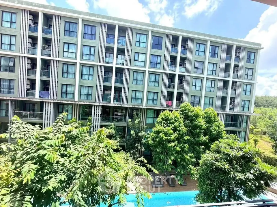 Modern apartment building with lush greenery and inviting pool view