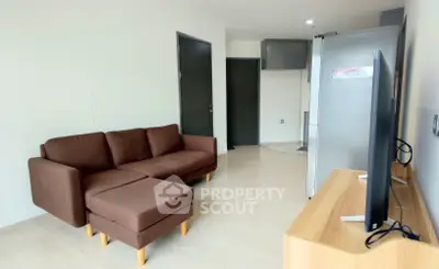 Modern living room with brown sofa and flat-screen TV, showcasing minimalist design and bright ambiance.