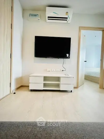 Modern living room with wall-mounted TV and air conditioning in a stylish apartment.