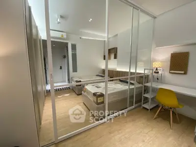 Modern bedroom with glass partition and study area in a stylish apartment