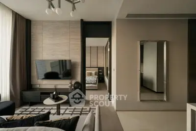 Modern living room with stylish decor and view into a cozy bedroom