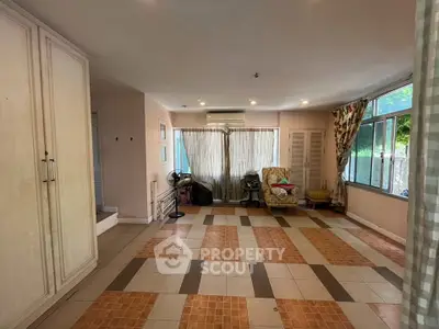 Spacious living room with large windows and tiled flooring in a cozy home.