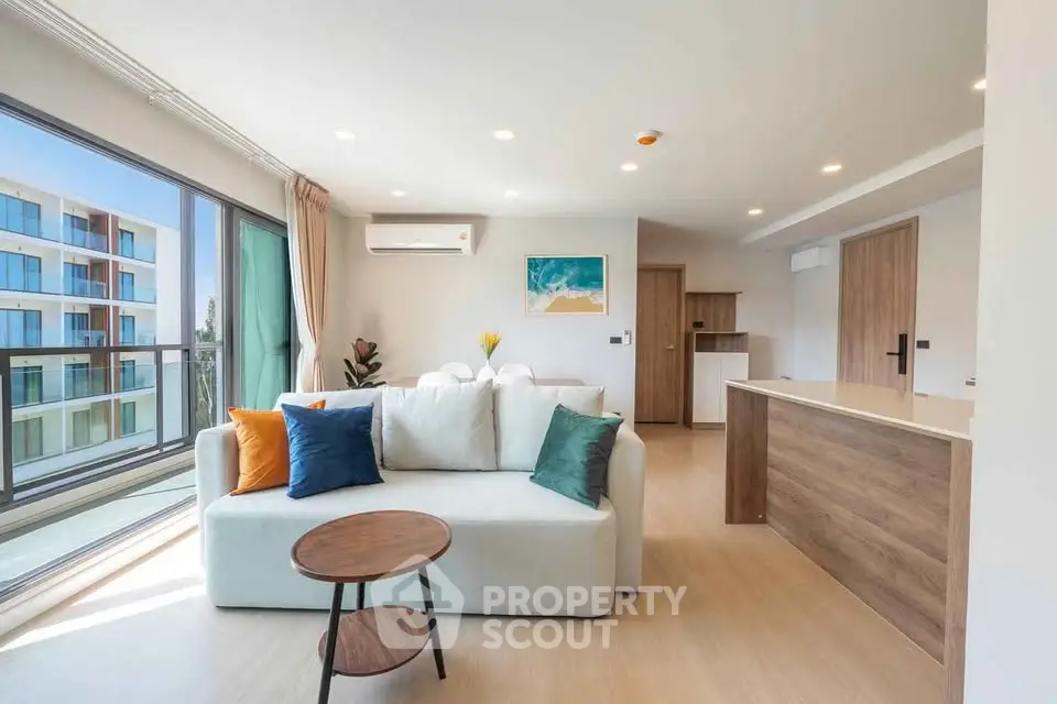 Spacious modern living room with large windows and stylish decor in a luxury apartment.