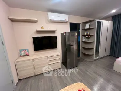 Modern bedroom with sleek furniture, wall-mounted TV, and stylish wardrobe.