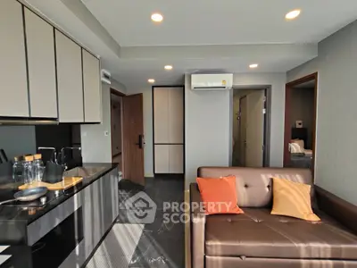 Modern living room with sleek kitchen and cozy sofa, perfect for urban living.