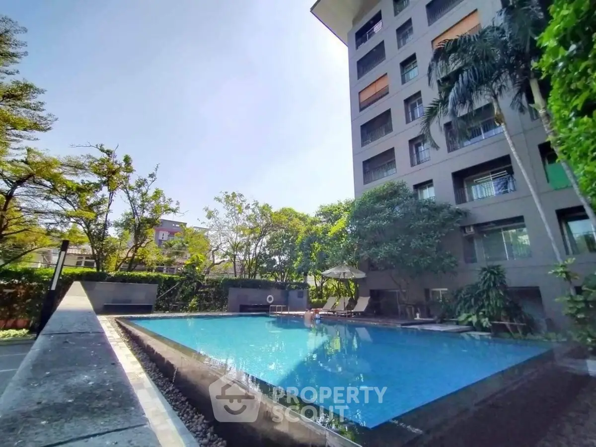 Luxurious apartment building with serene outdoor pool and lush greenery