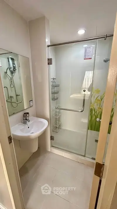 Modern bathroom with glass shower enclosure and sleek fixtures in a contemporary apartment.