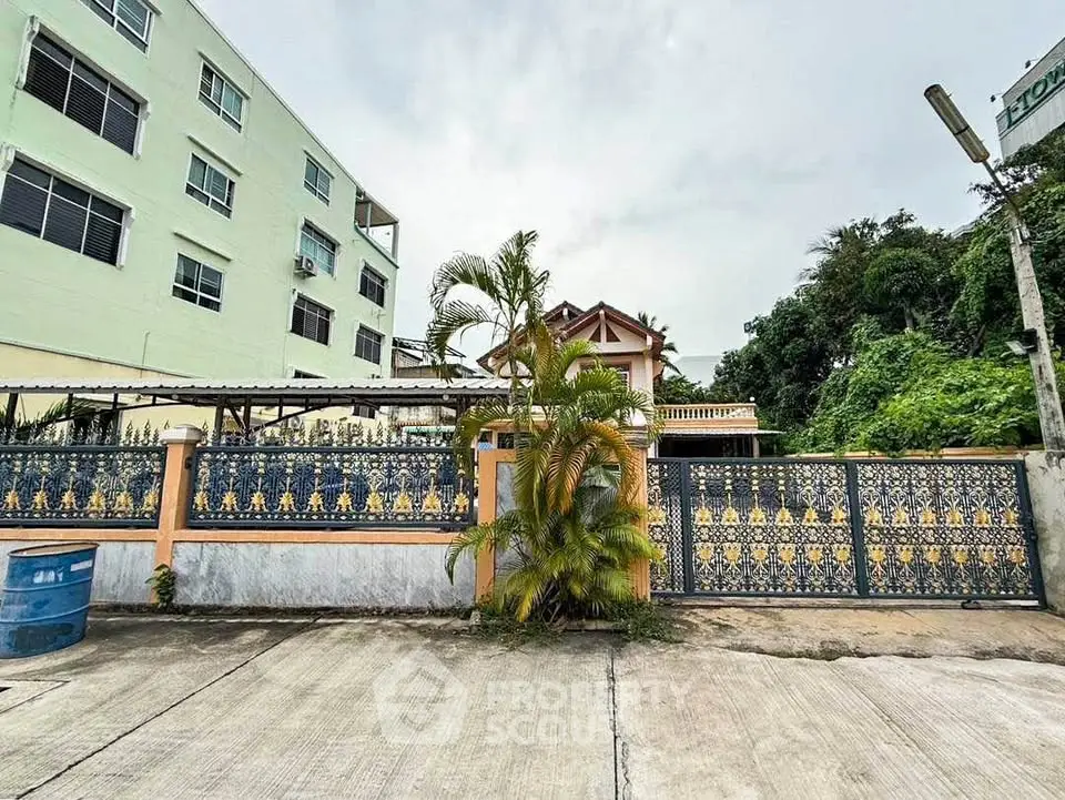 Charming residential building with ornate gate and lush greenery