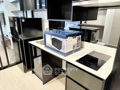 Modern kitchen with sleek appliances and stylish cabinetry in a contemporary apartment.