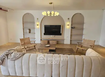 Elegant living room with modern decor, featuring a plush sofa, stylish chairs, and a wall-mounted TV for a cozy ambiance.