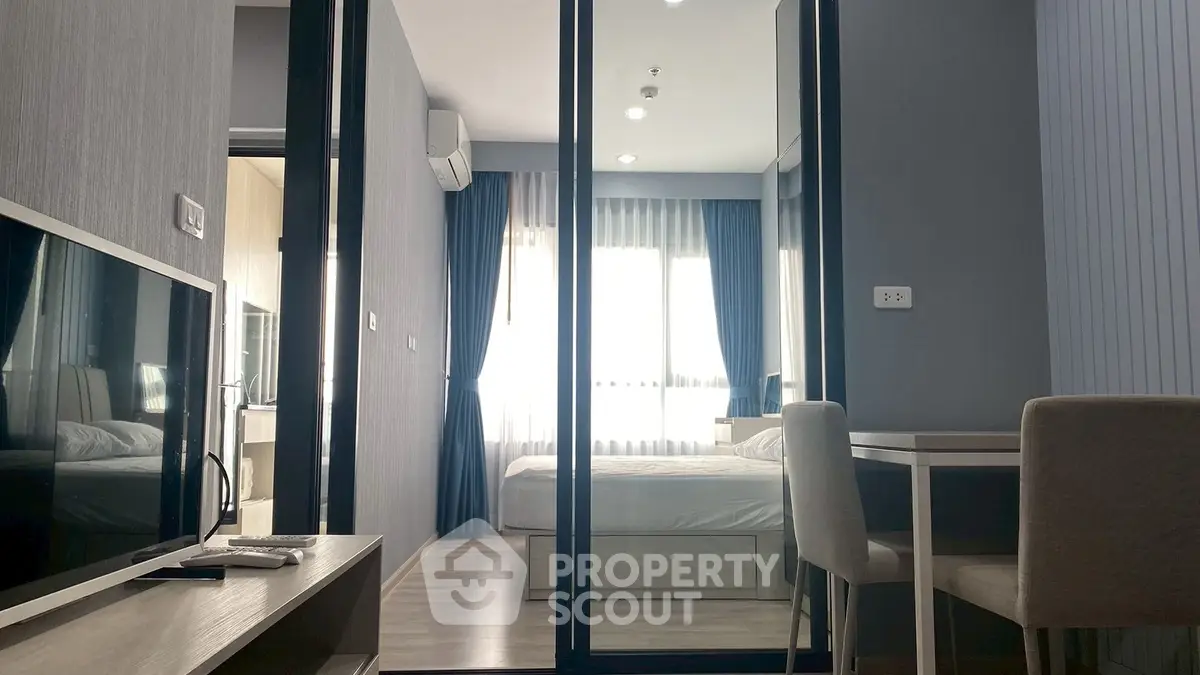 Modern apartment interior with bedroom, living area, and dining space, featuring sleek design and natural light.