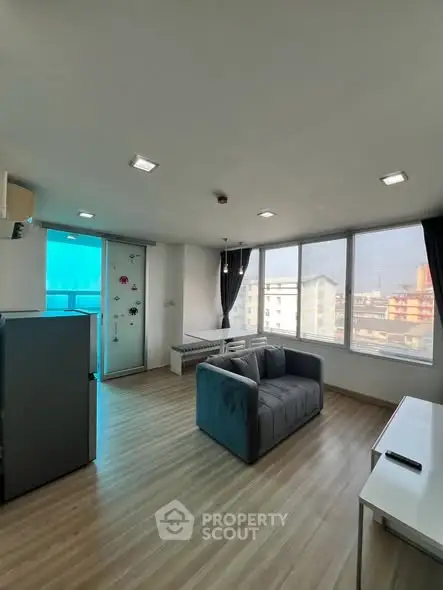 Modern living room with large windows and stylish furniture in a bright apartment.