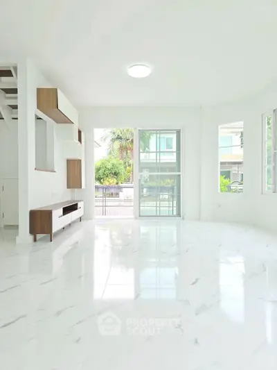 Spacious modern living room with marble flooring and large windows for natural light.