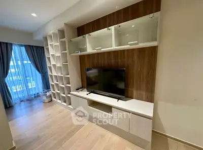Modern living room with built-in TV unit and large window with curtains.