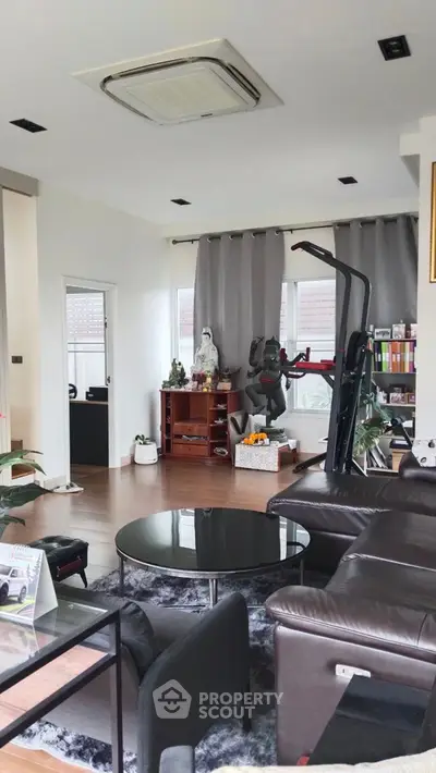 Spacious living room with modern decor and exercise equipment, perfect for relaxation and fitness.