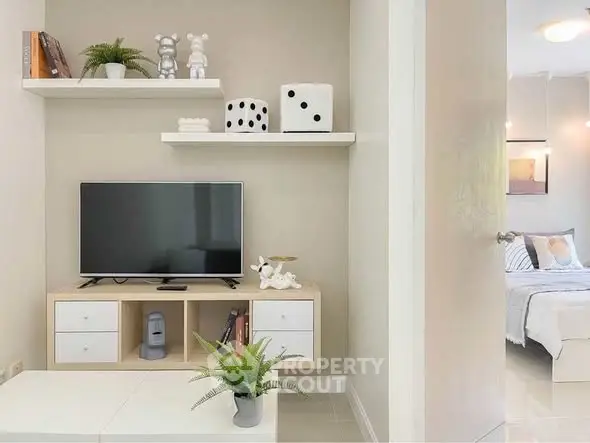 Modern living room with stylish decor and TV unit, adjacent to a cozy bedroom.