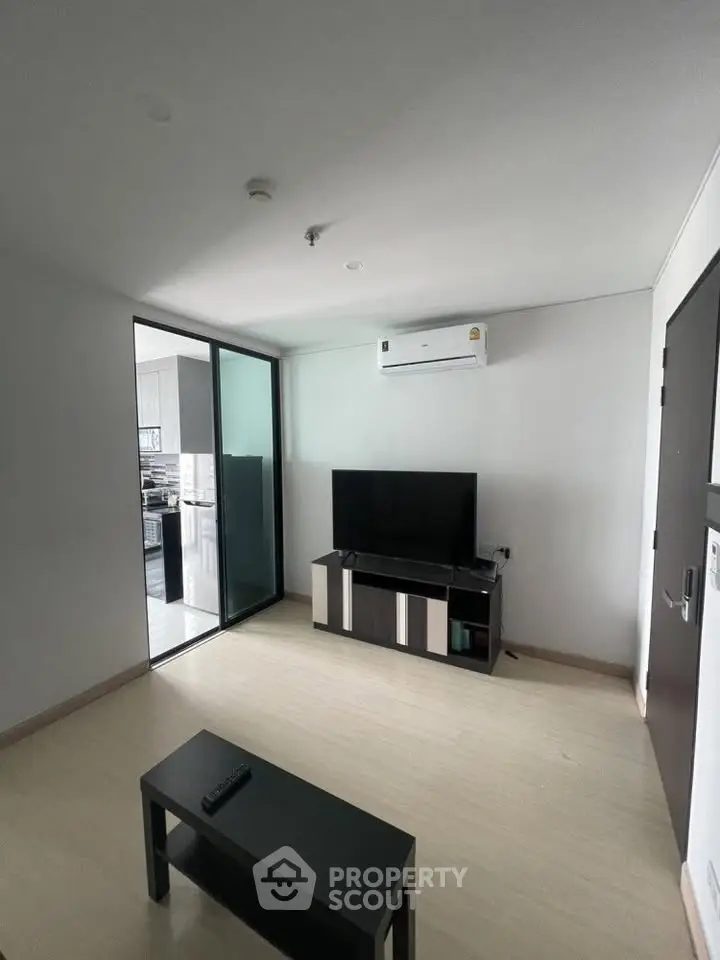 Modern living room with sleek TV setup and air conditioning in a stylish apartment.