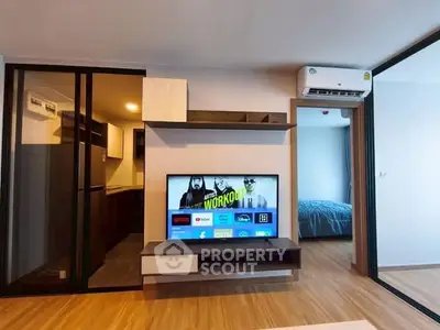 Modern living room with TV, air conditioning, and sliding glass doors to bedroom.