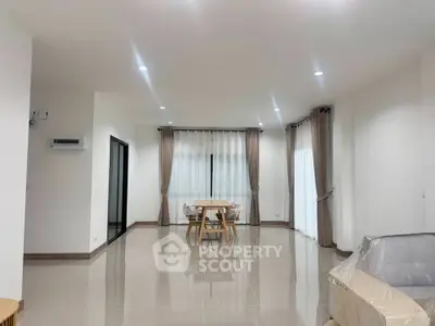 Spacious modern living room with sleek tile flooring and elegant curtains