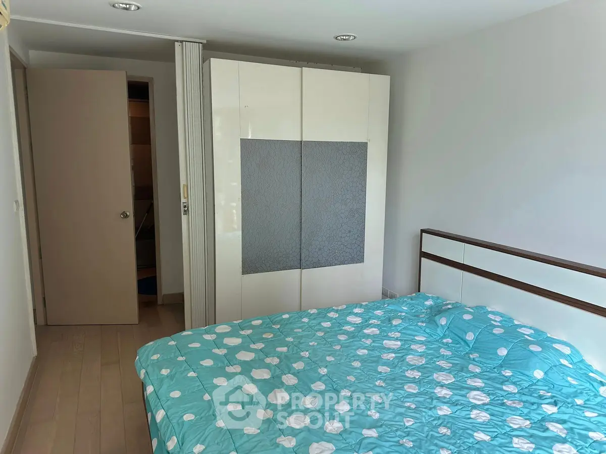 Cozy bedroom with modern wardrobe and stylish bedding in a bright apartment.