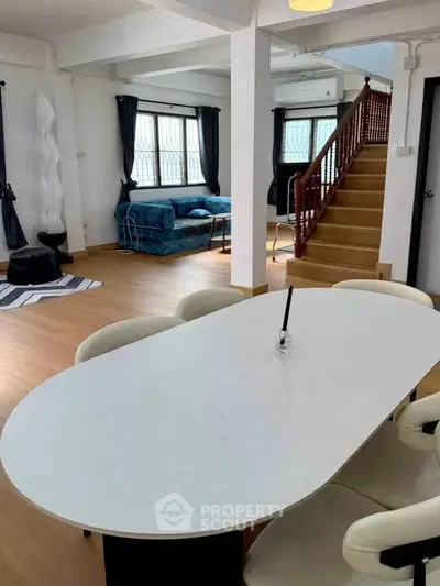 Spacious living room with modern furniture and elegant staircase in a stylish home.