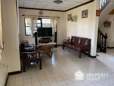 Spacious living room with classic wooden furniture and tiled flooring