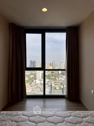 Stunning city view from a cozy bedroom window in a high-rise apartment.