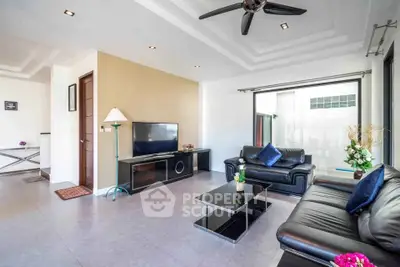 Spacious modern living room with leather sofas and sleek decor in a bright, airy setting.