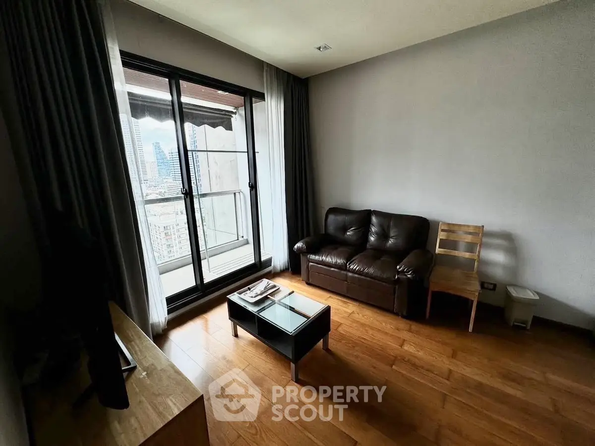 Cozy living room with city view balcony, wooden flooring, and modern furniture.