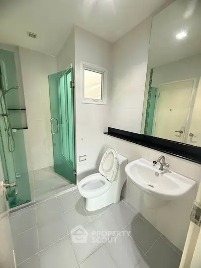 Modern bathroom with glass shower and sleek fixtures in a contemporary home.