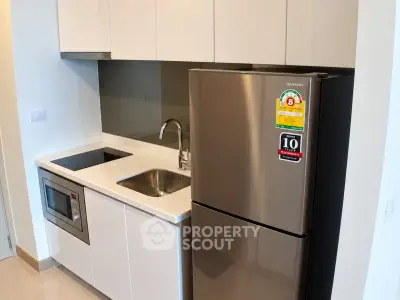 Modern kitchen with sleek appliances and minimalist design in a contemporary apartment.